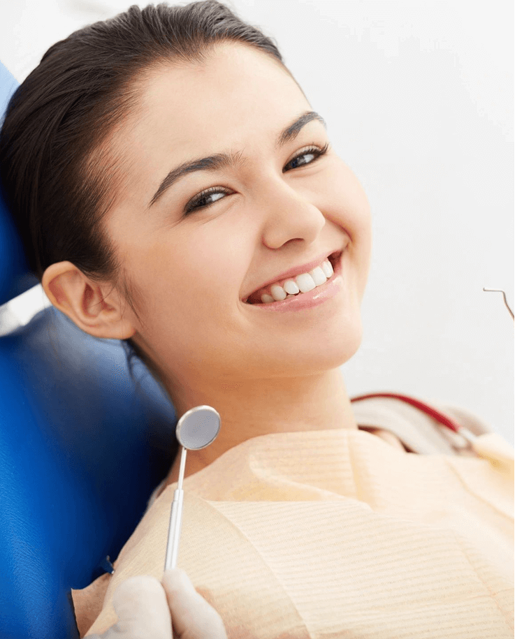 A woman sitting in the dentist chair smiling.