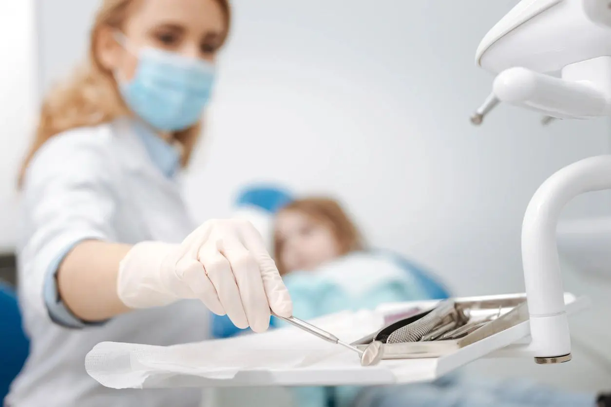 A dentist is working with the patient in his office.