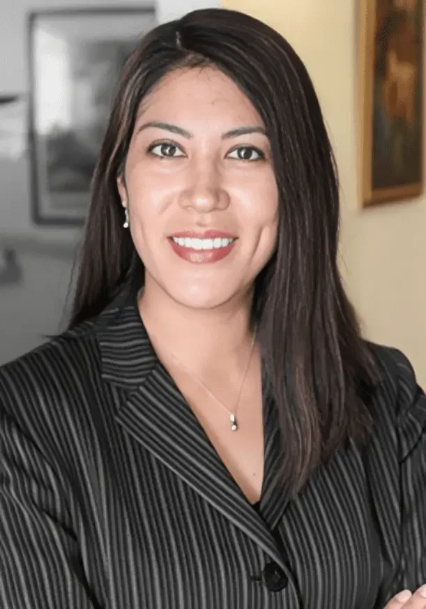 A woman in a black suit smiling for the camera.